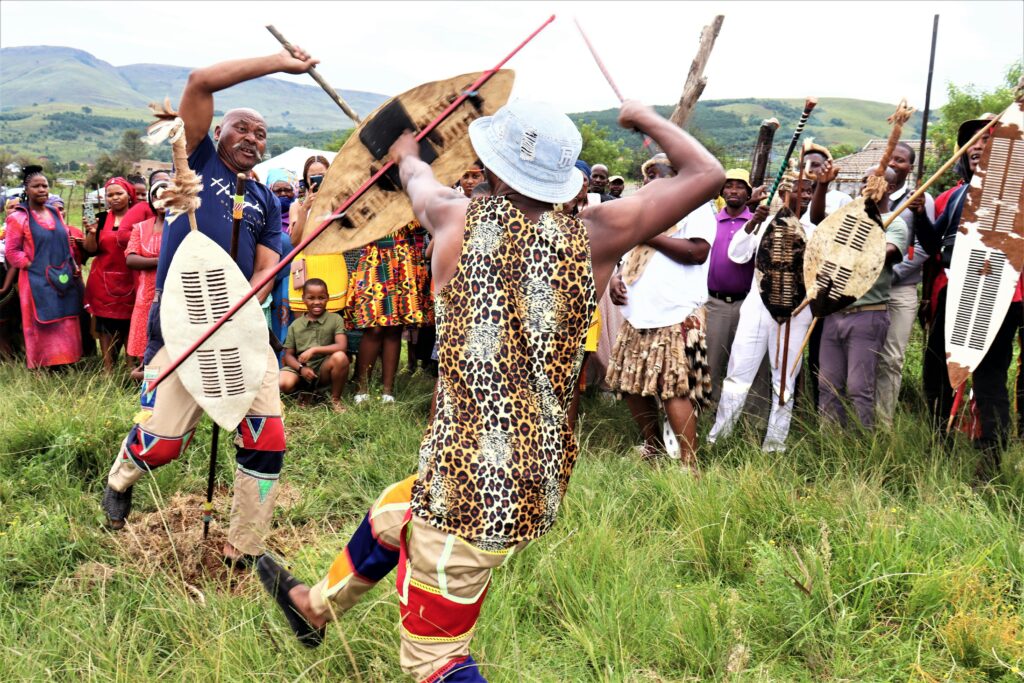 Vibrant display of traditional African dance and community gathering outdoors.
